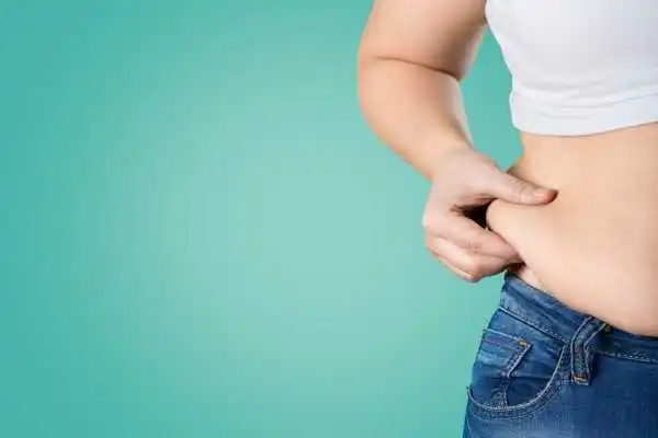 Image of woman pinching her love handles to show weight gain Cardiff