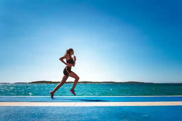 Woman running showing strong leg muscle Cardiff